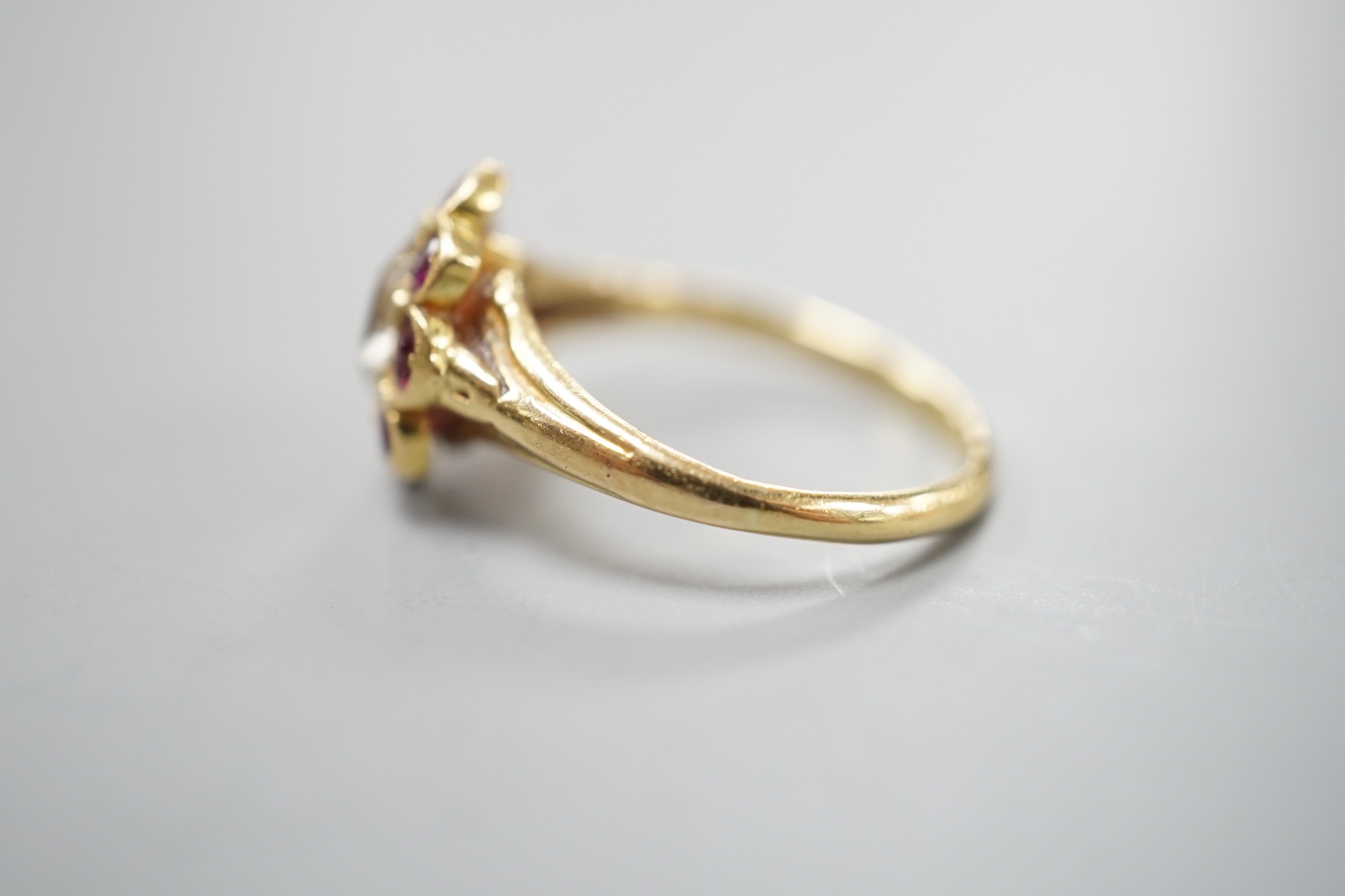 An early 20th century yellow metal and pear cut single stone diamond ring, with ruby set border, size O, gross weight 3.3 grams.